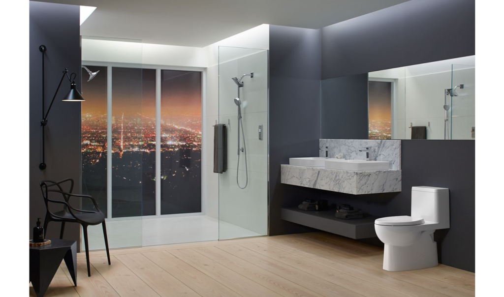 Salle de bain luxueuse dotée d'une toilette monopièce, d'une vanité double suspendue et d'une immense double à double robinetterie.
